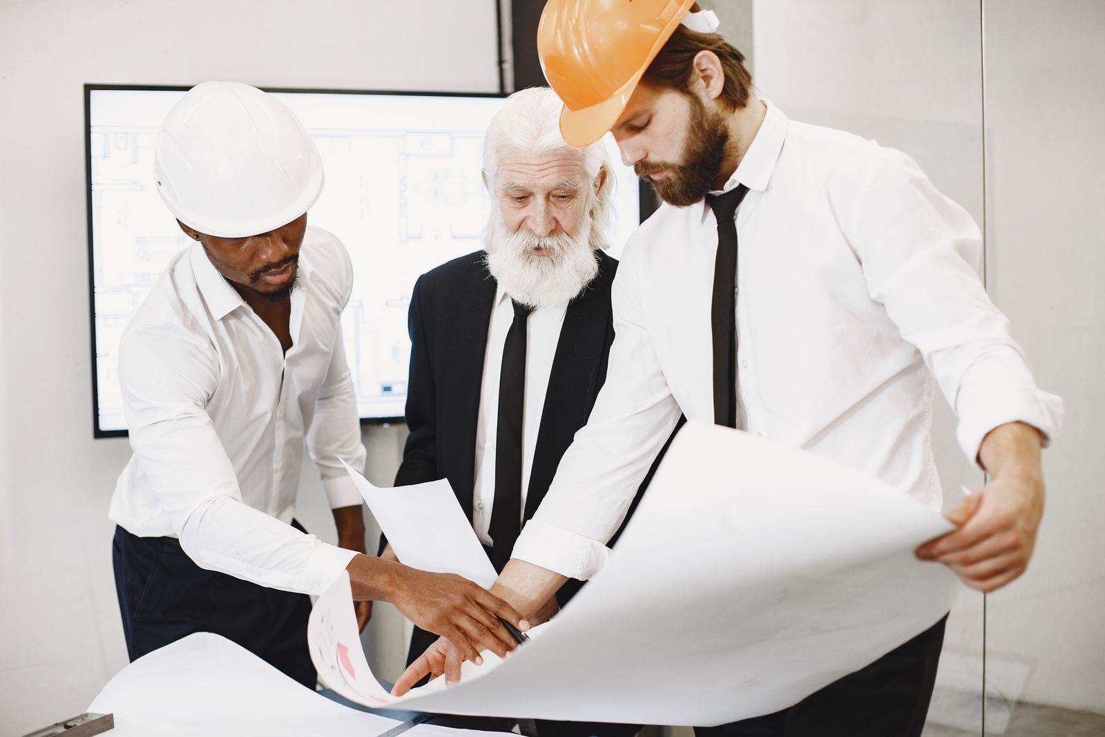Architects reviewing site plans on a table. Photo: Pexels